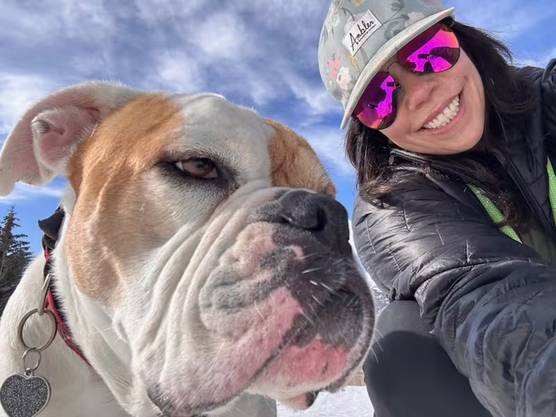 Courtney and her bulldog Scout in the snow